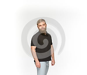 Closeup of young man`s body in empty black t-shirt isolated on white background. Mock up for disign concept
