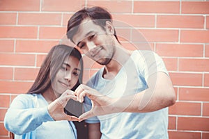 Closeup of young man and woman asian making heart shape with hand.