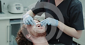 Closeup young patient in a dental clinic room sitting in the dentis chair and waiting till his dentist are fixing the