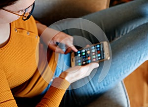 Closeup of young woman from above using smart phone at home yellow orange colors