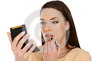 Closeup of young woman applying lipstick, holding small mirror