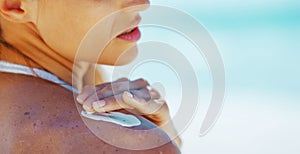 Closeup on young woman applying sun screen creme