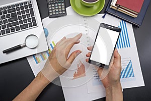 Closeup of a young woman checking accounts. Office desk table with supplies top view