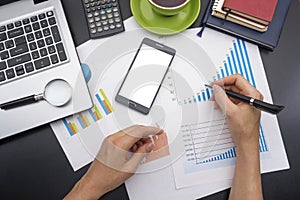 Closeup of a young woman checking accounts. Office desk table with supplies top view