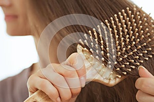 Closeup on young woman combing hair