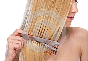 Closeup on young woman combing hair