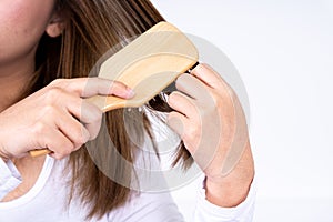 Closeup on young woman combing her hair. Daily life concept