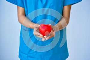 Closeup of young woman doctor hands with ball heart shape