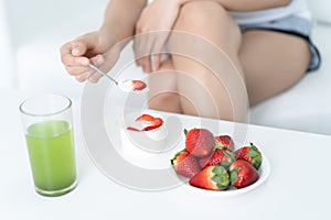 Closeup on young woman eating natural yogurt at home. Weight Los