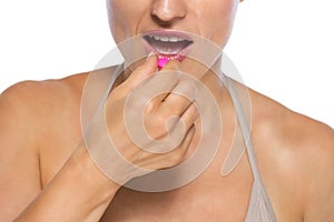 Closeup on young woman eating pill