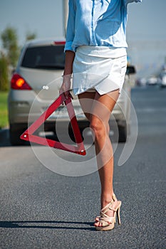 Closeup of young woman with emergency stop sign
