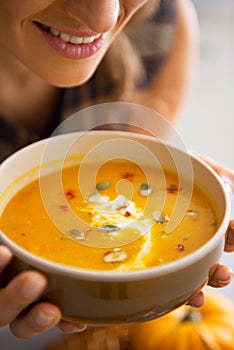 Closeup on young woman enjoying pumpkin soup