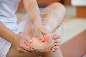 Closeup young woman feeling pain in her foot at home. Healthcare