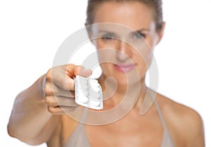 Closeup on young woman giving blistering package of pills