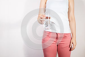 Closeup young woman holding drinking water glass in her hand