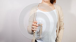 Closeup young woman holding drinking water glass in her hand