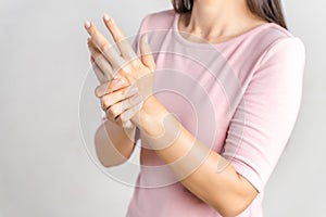 Closeup young woman holds her wrist on white background. hand injury, feeling pain. Health care and medical concept