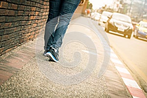 Closeup of young woman legs walk on sidewalk
