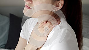 Closeup of young woman massaging her neck feeling pain. Concept of healthcare problems, pain relief and injuries.