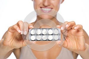 Closeup on young woman showing blistering package of pills