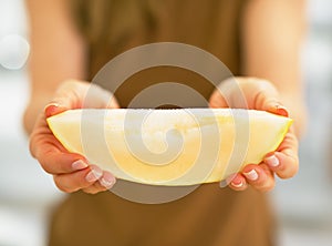 Closeup on young woman showing melon slice