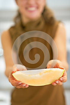 Closeup on young woman showing melon slice