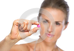 Closeup on young woman showing pill