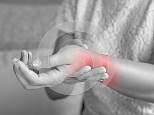 Closeup young woman sitting on sofa holds her wrist. hand injury