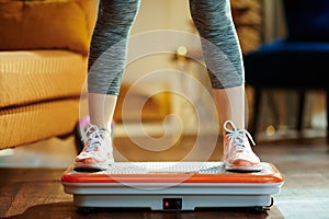 Closeup on young woman training using vibration power plate