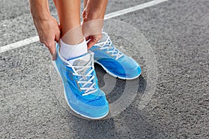 Closeup of Young Woman Tying Sports