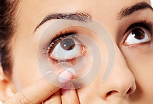 Closeup of young woman wearing contact lens.