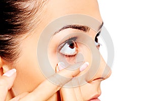 Closeup of young woman wearing contact lens.