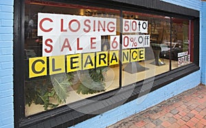 Closing clearance sale sign on storefront windo