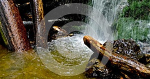 Closing-in shot of a waterfalls with logs