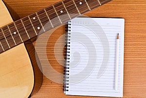 Closup Guitar and Blank notepad with pencil