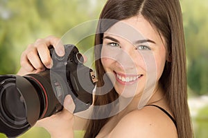 Closup portrait of woman photographer taking a photo with camera