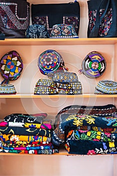 cloth bags, fabrics and skullcaps with a traditional bright colorful Turkmen pattern at oriental bazaar in Turkmenistan
