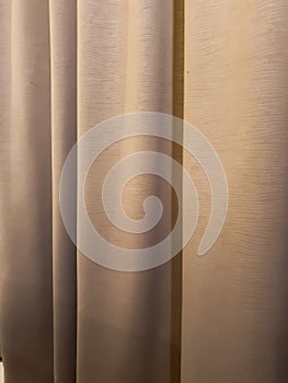 The cloth covering the badroom window is long and brown