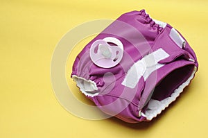 Cloth Diaper with Dummy on Yellow Background