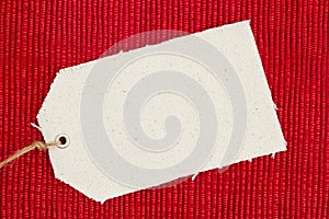 A cloth gift tag on shiny red material photo