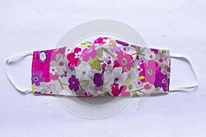 Cloth mask or fabric face mask with cotton fabric flower pattern handmade crafts isolated on white background. This hygienic mask.