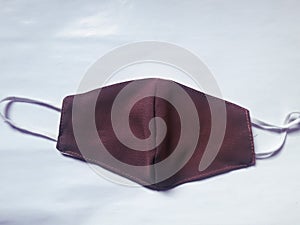 A cloth mask maroon color with white background
