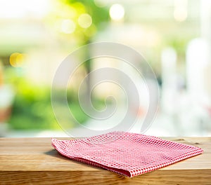 Cloth napkin on wood table with glass window background