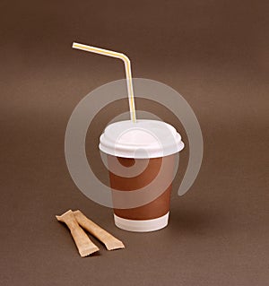 Clotheded take-out coffee with cup holder on brown background.