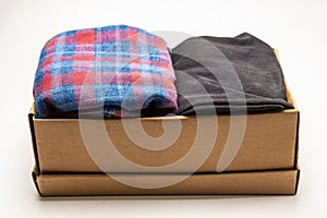 Clothes in a card box on a white background. Charity Help for people in need - box with donation clothes - Donation concept