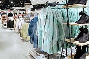 Clothes, coats on racks in clothing store, nobody