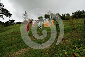 Clothes Drying On Hillside Line Under Cloudy Sky