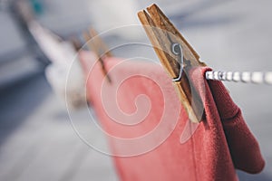 Clothes drying outdoors. Close-up wooden clothespin. Clothes hanging rope