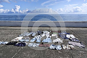 Clothes drying in sunlight on concrete waterfront