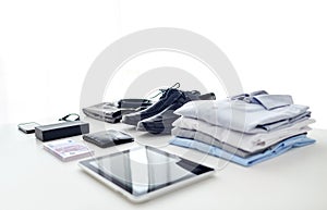 Clothes, gadgets and business stuff on table